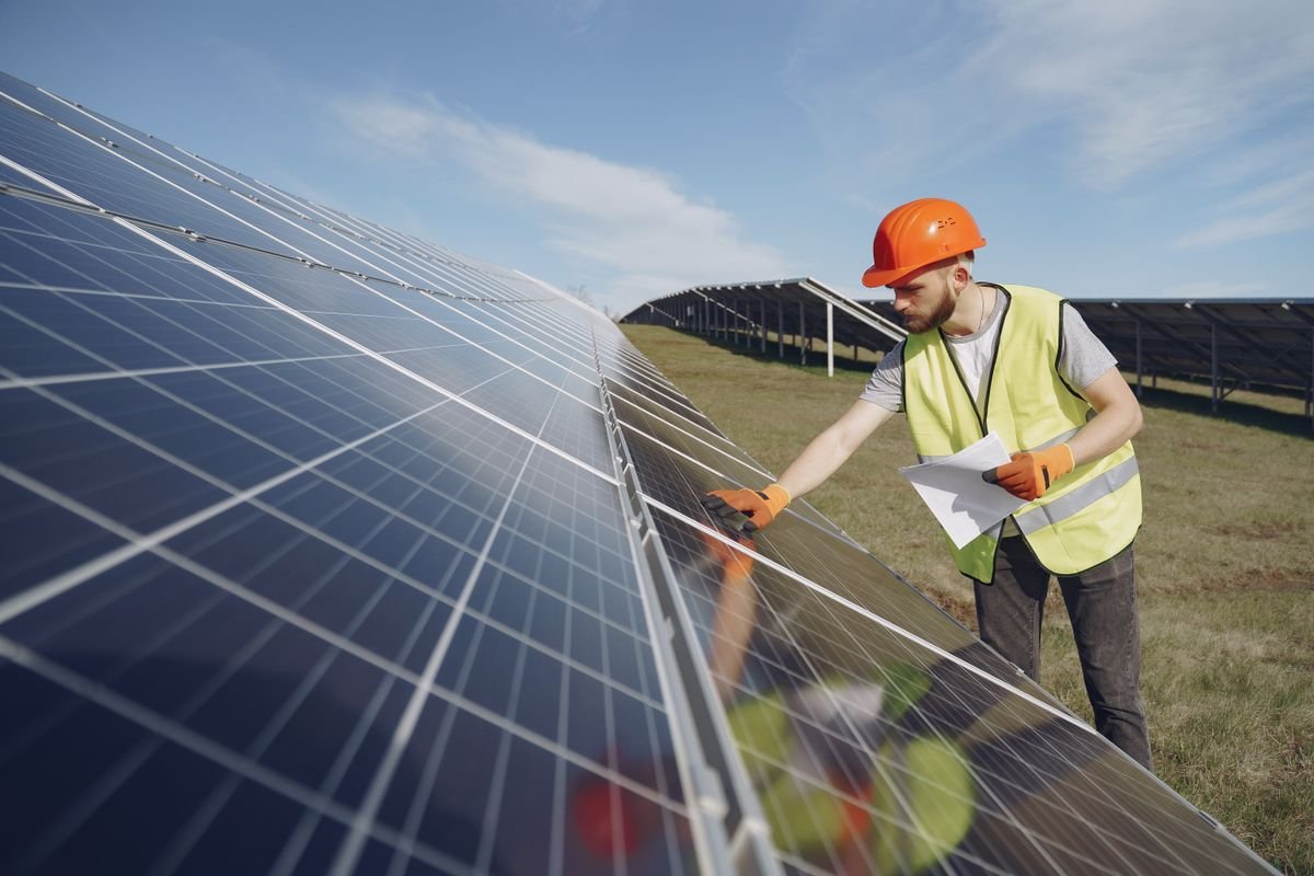 Technician performing solar panel maintenance and inspection